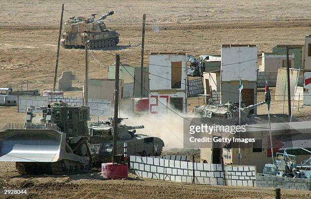 In this photo distributed by the Israeli Defense Forces , Israeli armor enters a model of a Palestinian village during a joint exercise of ground...