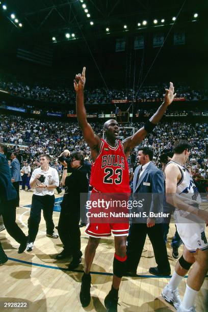Michael Jordan of the Chicago Bulls raises his hands to signal a 6th championship as he leaves the court after winning the NBA Championpship against...
