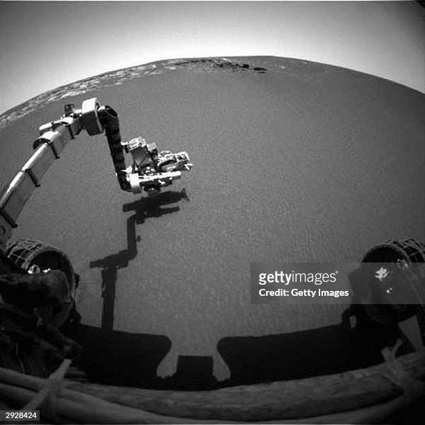 This image taken by the front hazard-identification camera onboard the Mars Exploration Rover Opportunity shows the rover's arm in its extended...