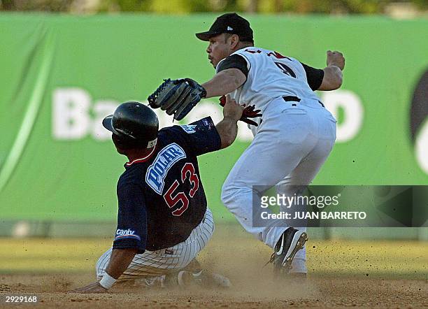 El jugador de segunda base Carlos Baerga de Leones de Ponce , en medio de una jugada en el cuadro, con Eduardo Rios de los Tigres de Aragua , en los...