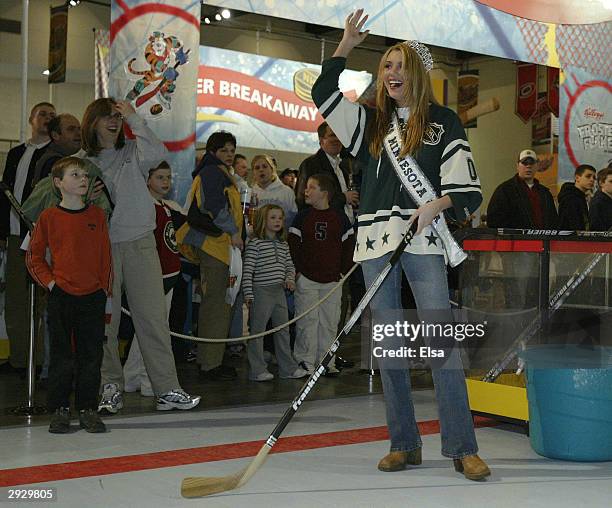Jessica Dereschuk, reigning Miss Minnesota, celebrates after she scored in the Shoot and Score contest in the NHL FANtasy area during the NHL...