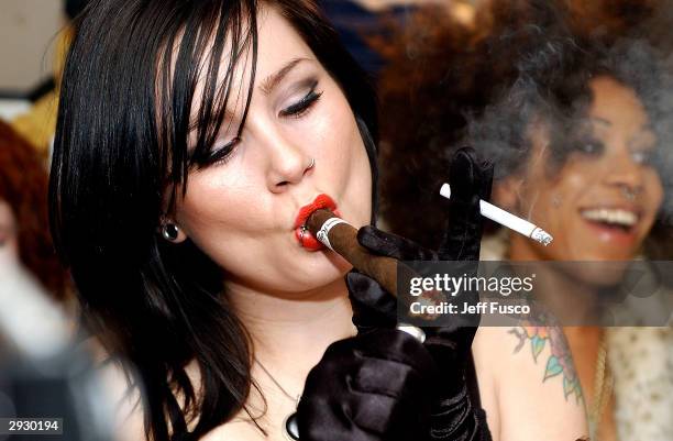 Suicide Girl Tegan lights a cigar backstage at The Trocedaro Theater February 4, 2004 in Philadelphia, PA. The burlesque act is made up of six women...