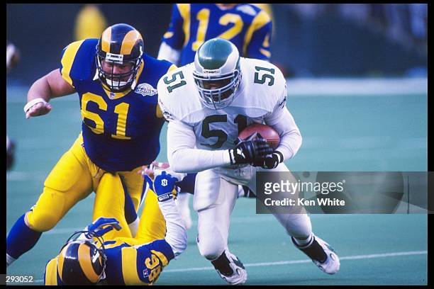 Linebacker William Thomas of the Philadelphia Eagles tries to break away from guard Bern Brostek and tight end Jessie Hester of the St. Louis Rams...