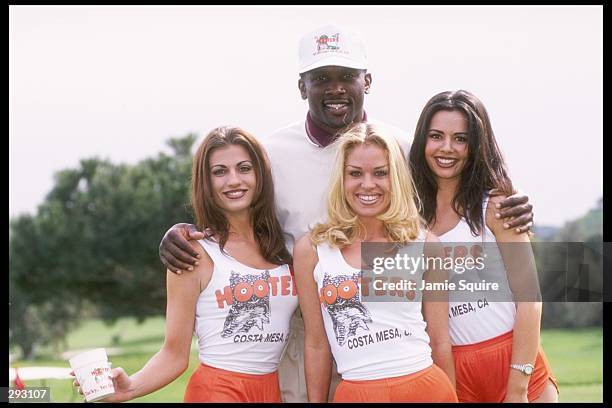 Tim Brown has his picture taken with some of the Hooters girls at the Celebrity Golf Classic in Bel-Air, California. Mandatory Credit: Jamie Squire...