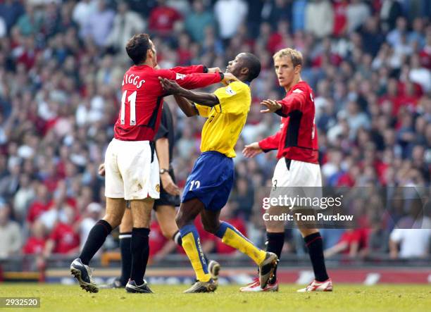 Ryan Giggs and Lauren of Arsenal confront each other during the FA Barclaycard Premiership match between Manchester United v Arsenal at Old Trafford...