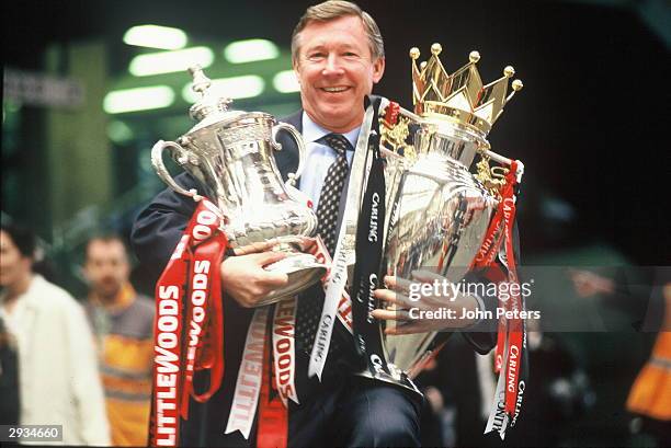 Manager Sir Alex Ferguson of Manchester United with the FA Cup and Premiership Trophy at Victoria Station, Manchester on May 12, 1996 after...