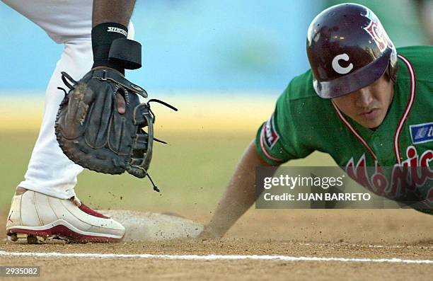 Heber Gomez de Los Tomateros de Culiacan , se desliza en la primera base en un juego contra Los Leones de Ponce , en partido por la Serie del Caribe,...