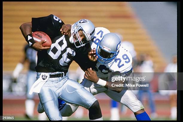 Wide receiver Mervyn Fernandez of the Los Angeles Raiders tries to break a tackle during a game against the Seattle Seahawks at the Los Angeles...