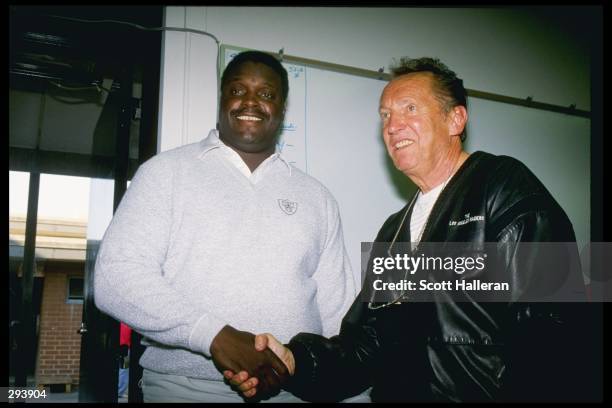 Coach Art Shell and owner Al Davis of the Los Angeles Raiders shake hands in Los Angeles, California.