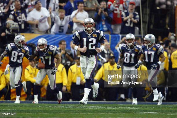 Quarterback Tom Brady of the New England Patriots, center, leads his teammates back onto the field for second half action against the Carolina...