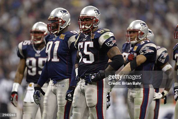 Defensive end Willie McGinest of the New England Patriots stands next to defensive end Bobby Hamilton in Super Bowl XXXVIII against the Carolina...