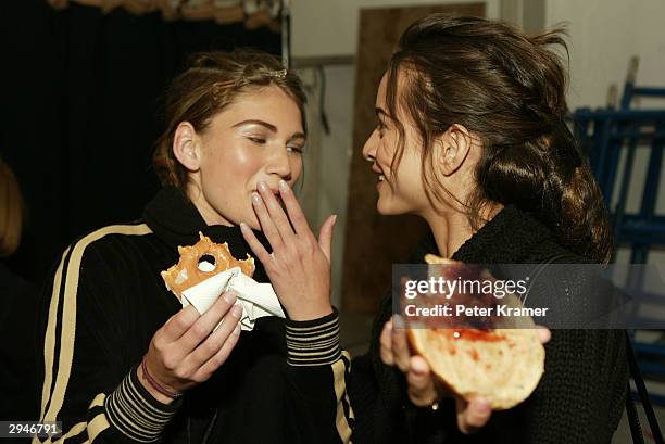 Models eat donuts and bagels as they get ready backstage at the Alice Roi fashion show during Olympus Fashion Week at Bryant Park February 8, 2004 in...