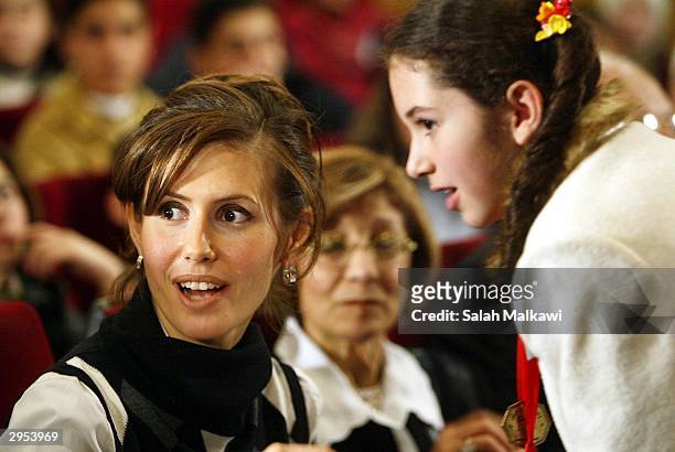 Asmaa al-Assad, wife of the Syrian President talks with a Syrian child as she attends the first national childhood conference, February 9, 2004 in...