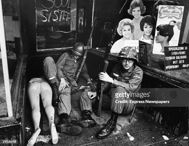 National Guardsmen take a break and rest in front of a hairdressers shop during race riots which took place in Newark, New Jersey, July 1967.