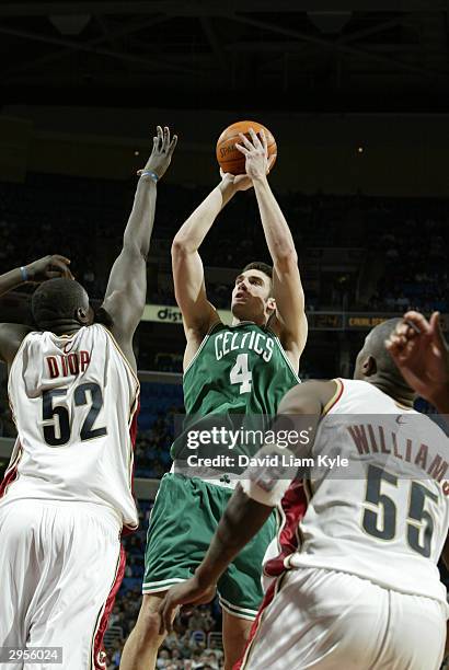 Chris Mihm of the Boston Celtics shoots over DeSagana Diop and Eric Williams of the Cleveland Cavaliers at Gund Arena on February 9, 2004 in...