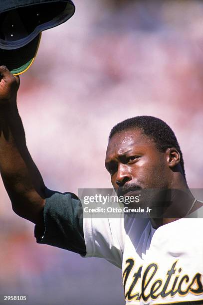 Pitcher Dave Stewart of the Oakland Athletics raises his cap in the air during a 1989 American League season game at the Oakland-Alameda County...