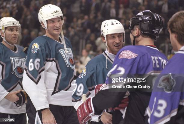 Centers Wayne Gretzky and Mario Lemieux of the Eastern All-Stars shake hands with center Viacheslav Fetisov of the Western All-Stars during the 47th...