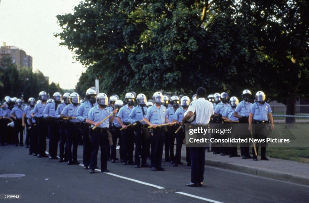 Rodeny Cane Riot Police officers stand in formation, wearing helmets and holding... News ...