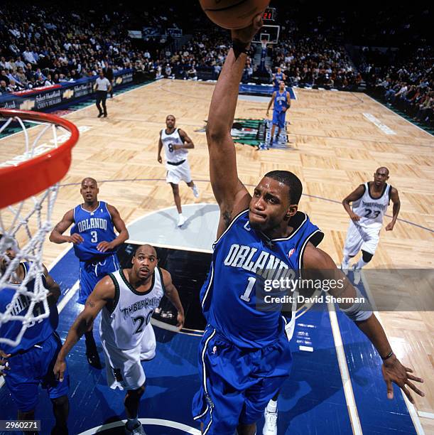 Tracy McGrady of the Orlando Magic goes up for a dunk during the game against the Minnesota Timberwolves at Target Center on February 3, 2004 in...