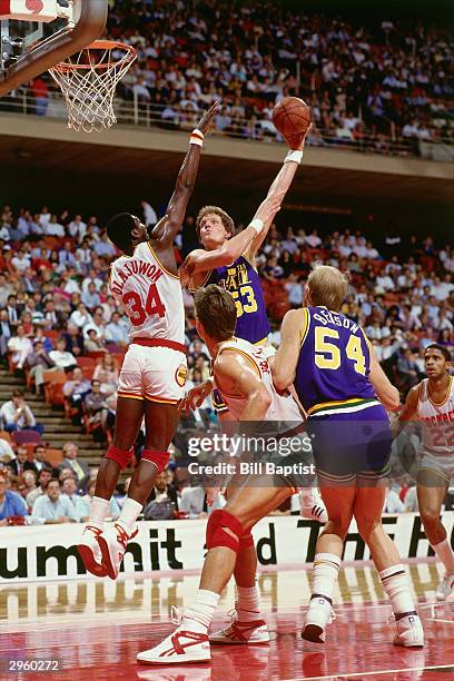 Mark Eaton of the Utah Jazz shoots a hookshot in the lane against Hakeem Olajuwon of the Houston Rockets during an NBA game at The Summit circa 1987...