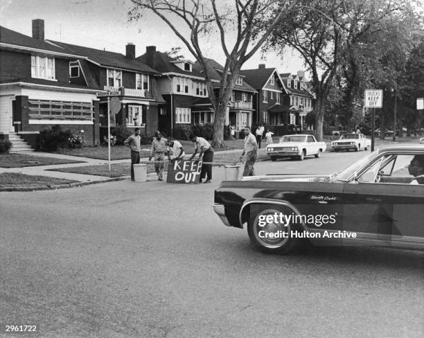 Group of men construct a barricade out of wood and garbage cans to keep their street safe during the riots, Detroit, Michigan, July 27, 1967....