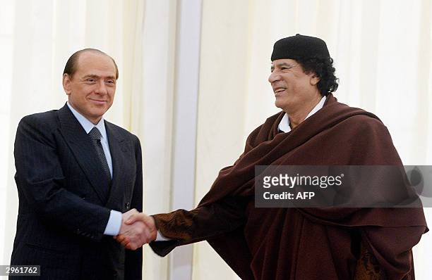 Libyan leader Moamer Kadhafi greets Italian Prime Minister Silvio Berlusconi during a meeting in Sirte, 10 February, 2004. Berlusconi is the first...