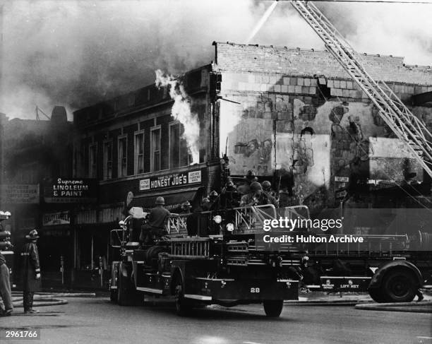 Federal troops ride on a fire engine to protect the firefighters from snipers during the riots in Detroit, Michigan, July 27, 1967.