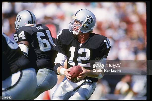 Quarterback Todd Marinovich of the Los Angeles Raiders looks to pass the ball during a game against the New York Giants at the Los Angeles Memorial...