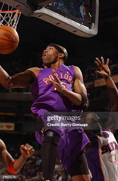 Vince Carter of the Toronto Raptors drives for a shot attempt under the basket against the Phoenix Suns on February10, 2004 at America West Arena in...