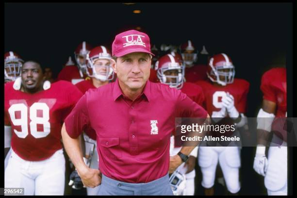 Coach Bill Curry of the Alabama Crimson Tide walks onto the field with his players before a game against the Kentucky Wildcats at Legion Field in...