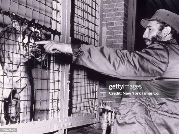 Cuban president Fidel Castro faces and points at a Bengal tiger in a cage at the Bronx Zoo, New York City, April 24, 1959.