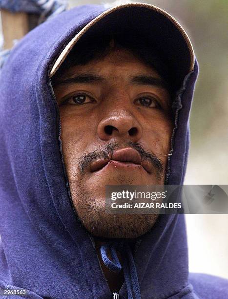 An inmate of the San Pedro jail in La Paz, Bolivia, shows his sewed mouth 11 February 2004 during the 10th day of a hunger strike. The inmates claim...