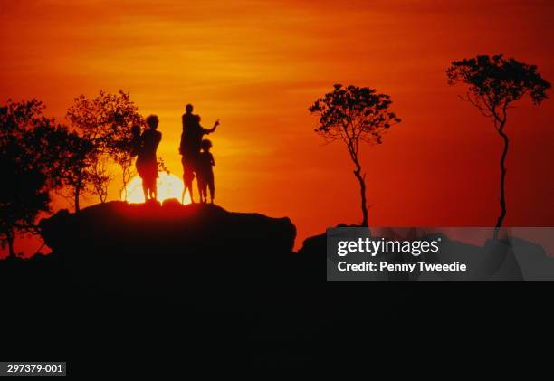 australia,arnhem land,dippirringur, silhouette of family on rock,sunse - kakadu stockfoto's en -beelden