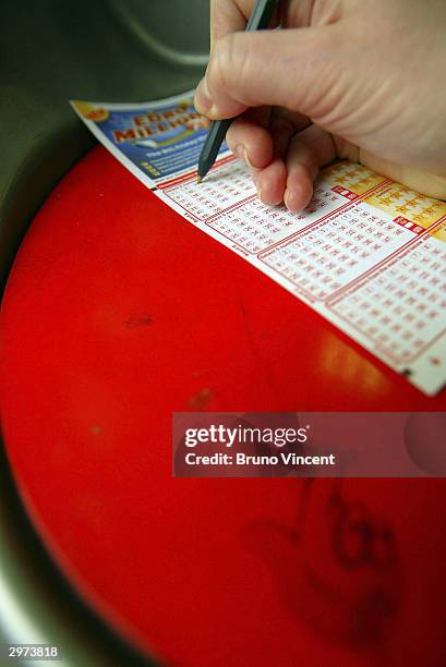 Woman fills out her ticket for the Euromillions first draw, February 12, 2004 in central London, England. The first draw of the new Euromillions...