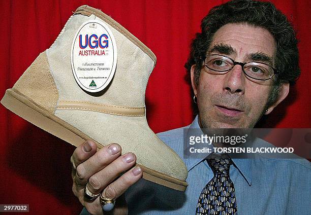 Retailer Alexander Garfield displays his best selling, Australian-made, sheepskin Ugg boots at a discount store in Sydney, 13 February 2004, despite...