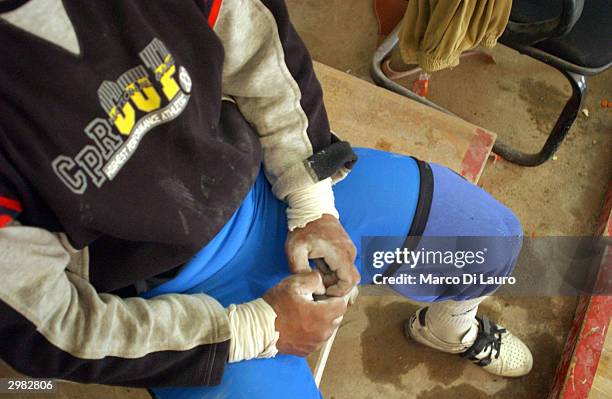 An Iraqi weightlifter prepares for his training session to qualify for the Olympics at a makeshift gym February 14, 2004 in Baghdad, Iraq. Iraq is...