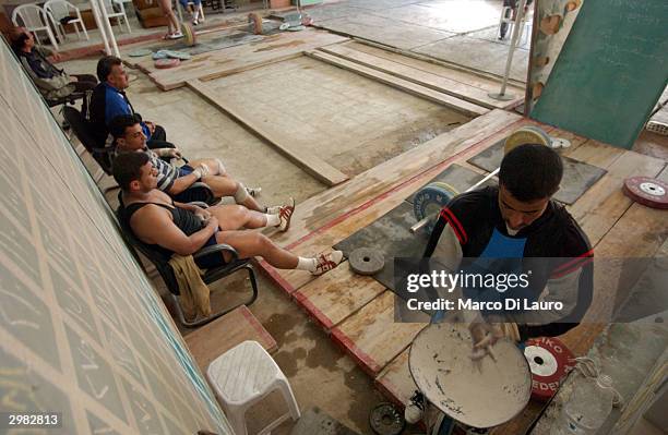 An Iraqi weightlifter prepares for his training session to qualify for the Olympics at a makeshift gym February 14, 2004 in Baghdad, Iraq. Iraq is...