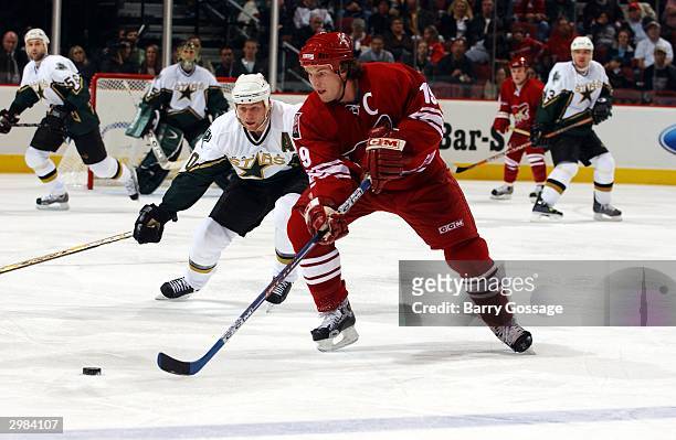 Shane Doan of the Phoenix Coyotes skates with the puck against the Dallas Stars on February 14, 2004 at Glendale Arena in Glendale, Arizona. The...