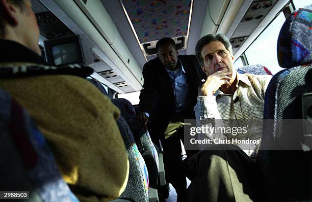 Senator John Kerry sits with supporters on his campaign bus during a trip to a rally in Green Bay February 16, 2004 on State Road 29 East in...