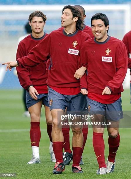 Portuguese players Ruiz Costa and Deco smile during the team's training session at the Algarve stadium in Faro, Portugal, 17 February 2004 on the eve...