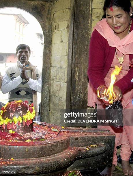 Nepalese Hindu woman offers prayers to a Shiva-Lingam, a stone idol representing the phallic symbol of the God Lord Shiva, on the occasion of the...