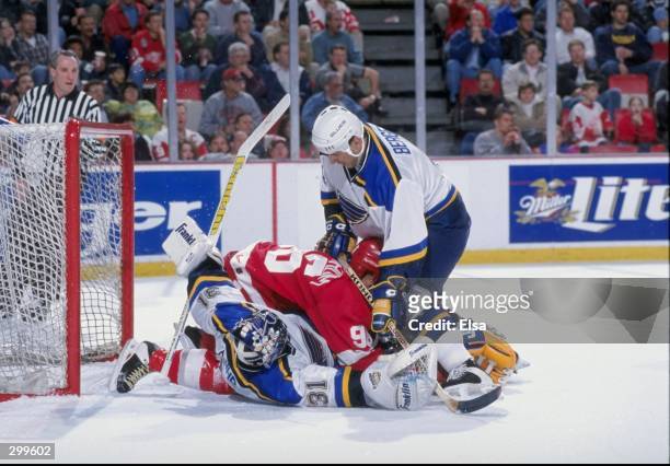 Goaltender Grant Fuhr and defenseman Eric Bergevin of the St. Louis Blues in action against leftwinger Tomas Holmstrom of the Detroit Red Wings...