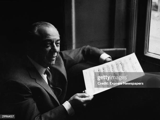 American composer Richard Rodgers smiles and holds a musical score while in rehearsal for the musical, 'The Boys From Syracuse,' written with...