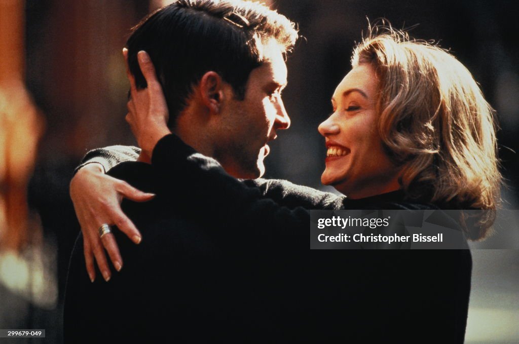 Couple embracing outdoors, close-up