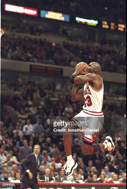 Guard Michael Jordan of the Chicago Bulls takes to the air in his famous moves to slam dunk against the Charlotte Hornets at the United Center in...
