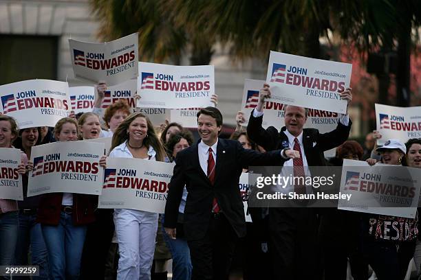 Democratic presidential candidate Senator John Edwards walks with supporters on his way to deliver a stump speech at Johnson Square February 20, 2004...