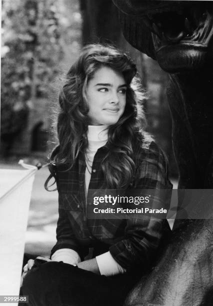 American actor and model Brooke Shields sits by a statue during a tour of the Princeton University campus before becoming a student, September 1981.