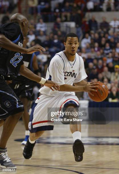 Marcus Williams of the University of Connecticut Huskies looks to pass the ball by Gerald Riley of the Georgetown Hoyas during the game on January...