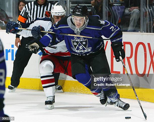 Alexander Frolov of the Los Angeles Kings gets hooked by Luke Richardson of the Columbus Blue Jackets in the second period on February 21, 2004 at...