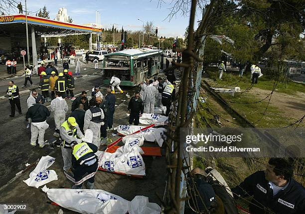 Israeli police and ultra-Orthodox rescue volunteers gather victims' bodies at the scene of a Palestinian suicide bombing on a passenger bus February...